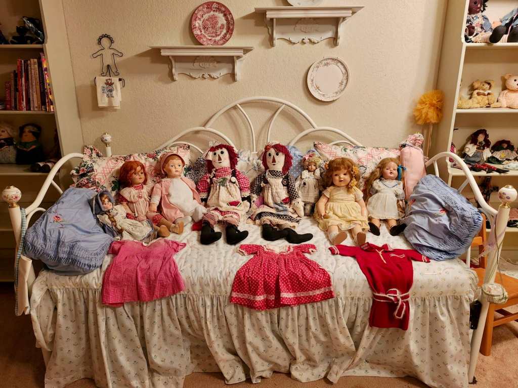 A bed adorned with Raggedy Ann twins & baby dolls.
