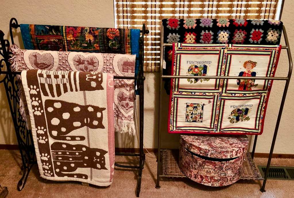 Quilt racks adorned with an array of cozy, comforting quilts.